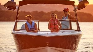 kids and adults on a boat on a lake